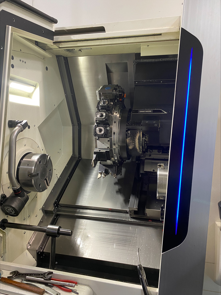 Das Innere einer CNC-Drehmaschine mit verschiedenen Werkzeugen und Spänen ist zu sehen. Das Innere einer CNC-Drehmaschine mit verschiedenen Werkzeugen und Spänen ist zu sehen.